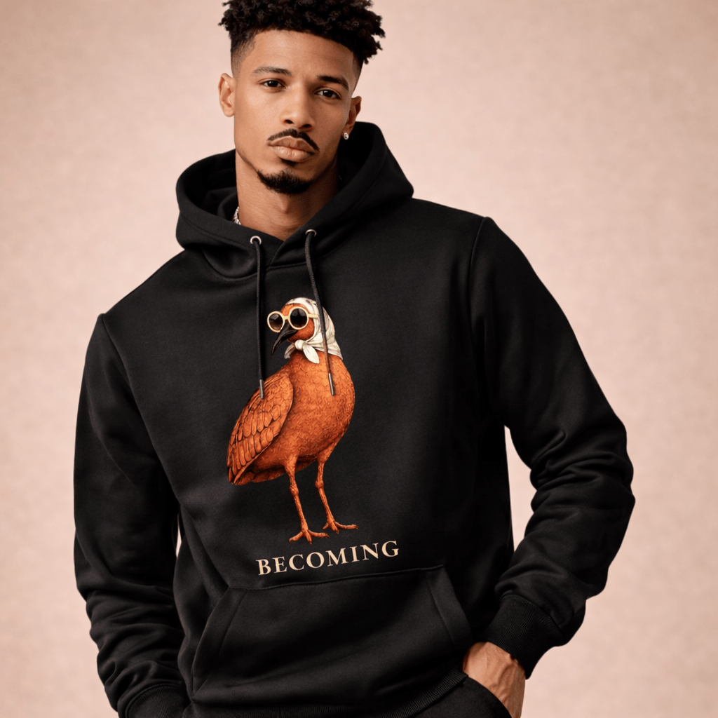 Man wearing a black hoodie with a graphic of a bird and the word 'BECOMING' on a beige background