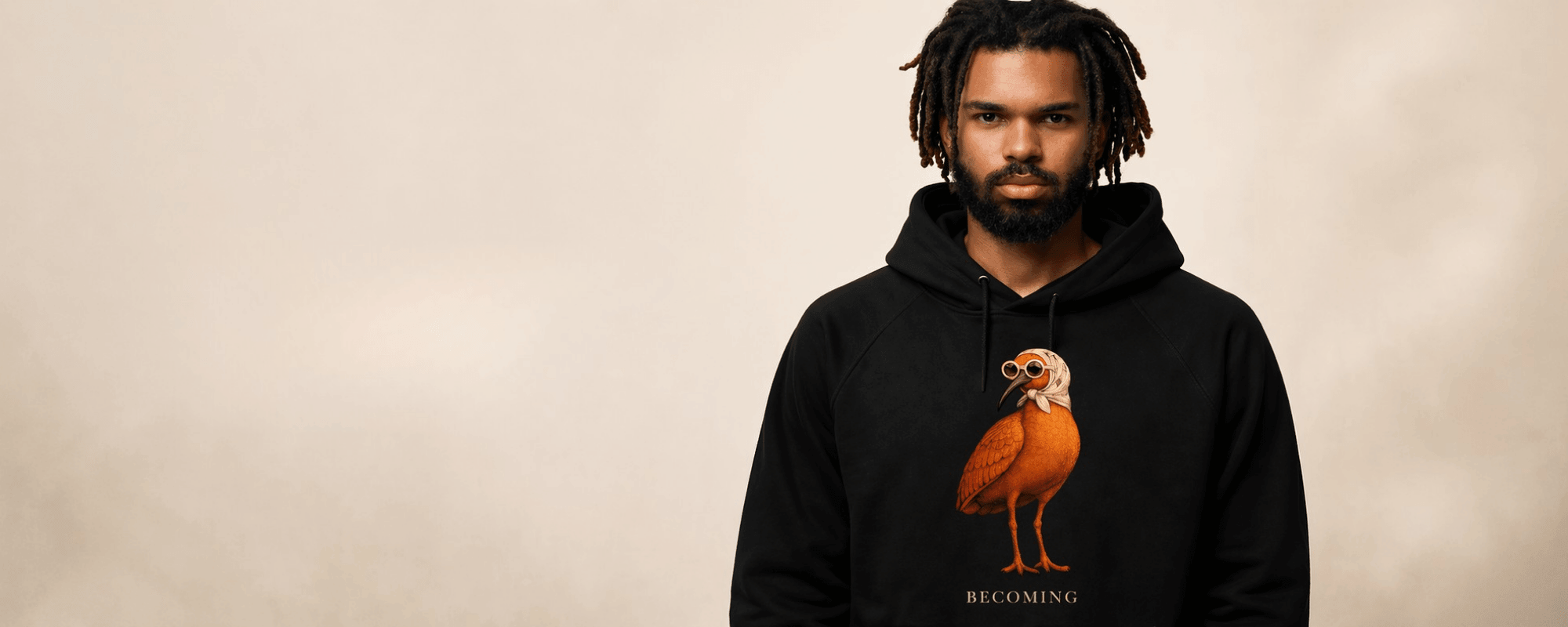 Man wearing a black hoodie with a bird graphic on a beige background