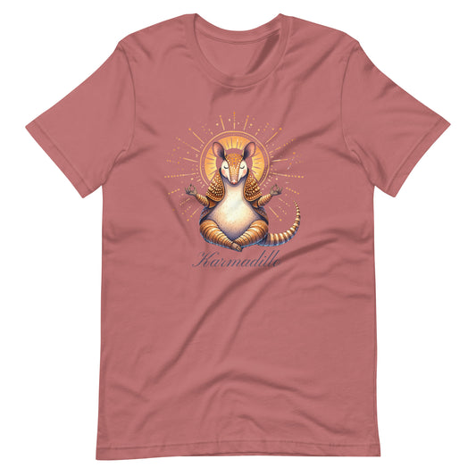 Mauve t-shirt featuring a "Karmadillo" design with a meditating armadillo radiating peaceful energy. 