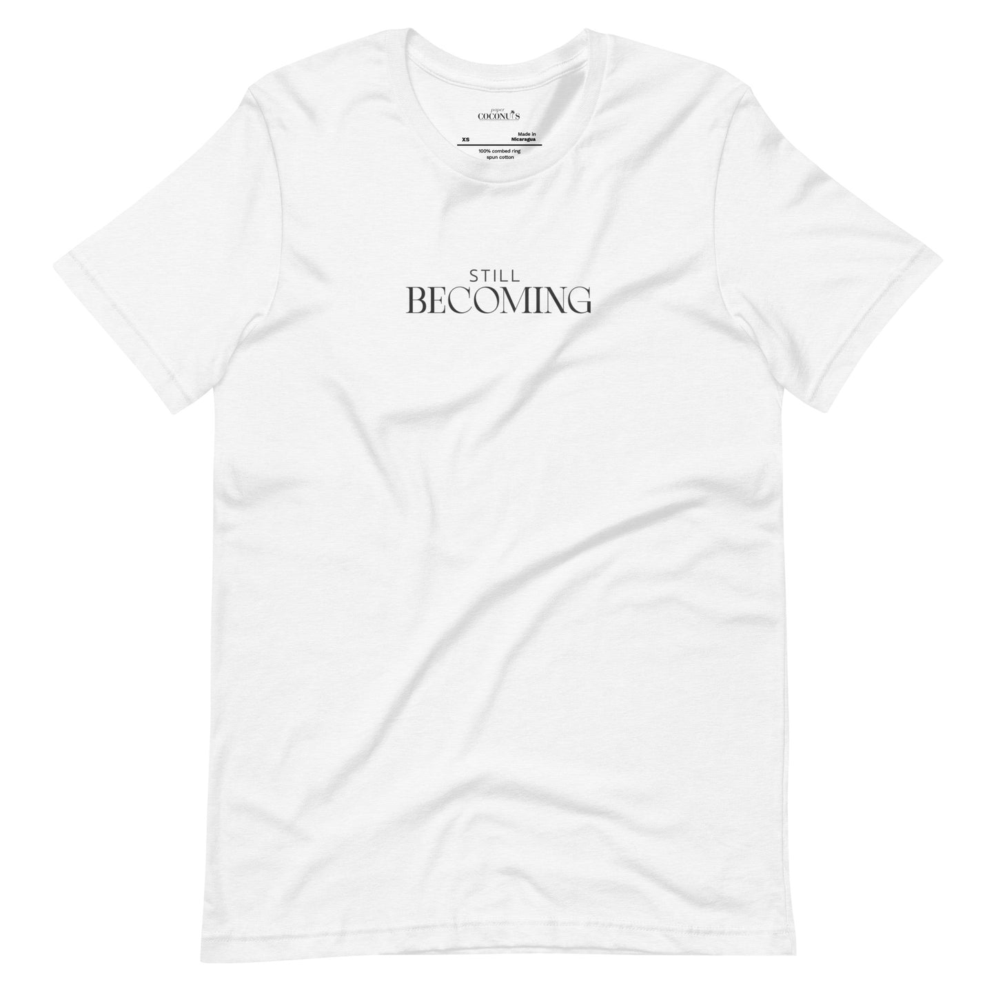 White unisex graphic t-shirt with Still Becoming text design by Paper Coconuts, minimalist style for everyday comfort